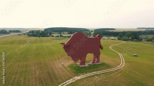 Huge bison statue in the middle of fields aerial view