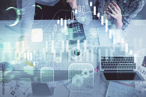 Double exposure of man and woman working together and financial graph hologram drawing. market analysis concept. Computer background. Top View.