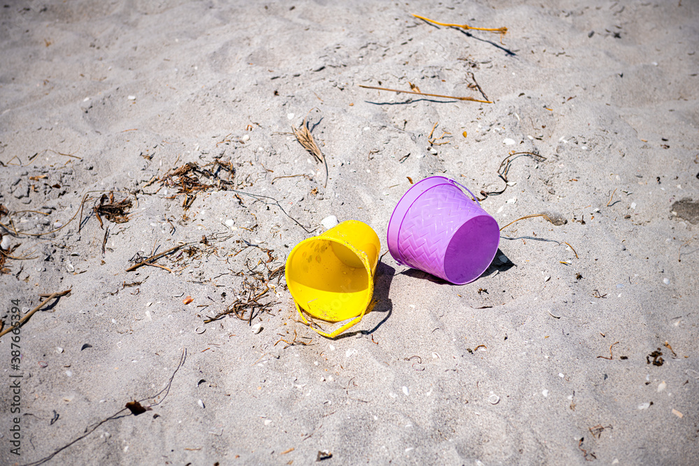 Sanibel Island Bowman's beach with sand and colorful buckets for children playing and nobody by seaweed Sanibel Island Bowman's beach with sand and colorful buckets for children playing and nobody by seaweed