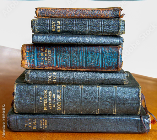 Stack of old leather bound bibles and prayer books. photo