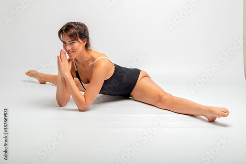 beautiful brunette is engaged in yoga in the studio on a white background
