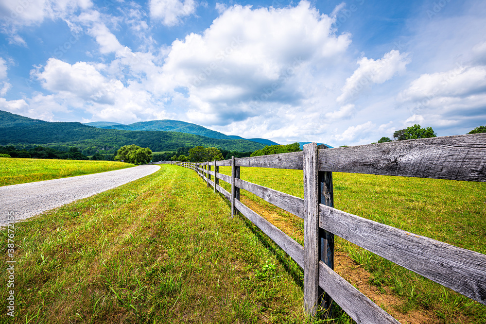 Farm road fence closeup in Roseland, Virginia near Blue Ridge parkway mountains in summer with idyllic rural landscape countryside in Nelson County
