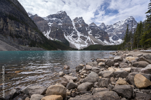 Beautiful alpine lake with turquoise waters surrounded by magnificent peaks, low perspective shot made on a overcast day at Moraine Lake, Banff National Park, Alberta, Canada