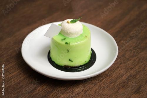 Lime green mousse cake on wooden table - cafe vibe                                photo