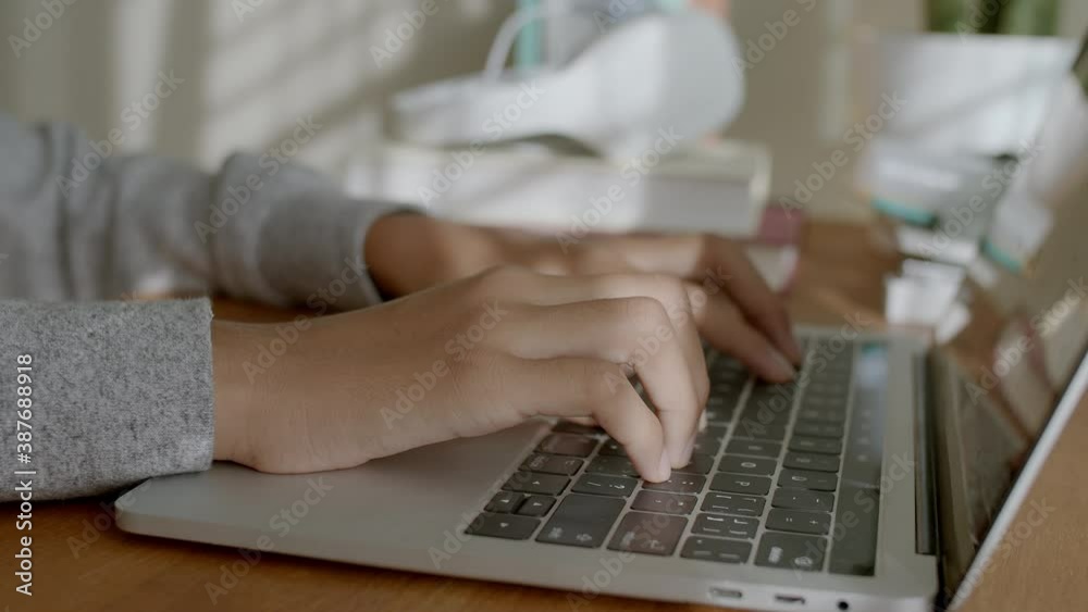 Hand of woman Asian typing on laptop computer at home and morning sunlight Hand of woman Asian typing on laptop computer at home and morning sunlight