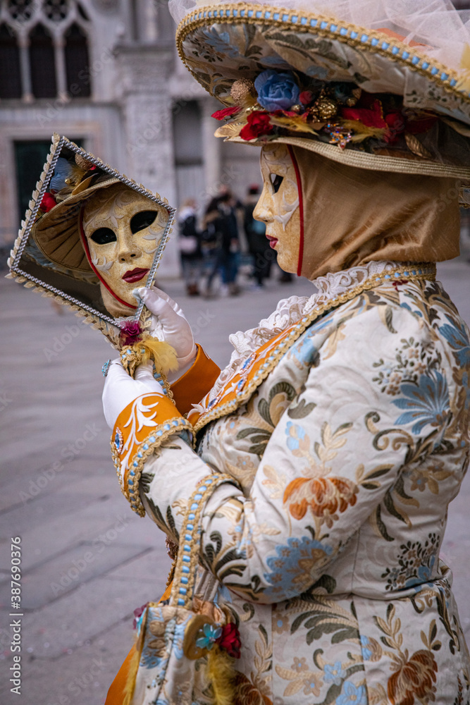 Carnival costume looking in mirror at St. Mark’s Square in Venice Italy