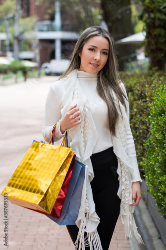 mujer sonriente con paquetes de compras en las manos, mujer de compras, mujer comprando regalos para navidad