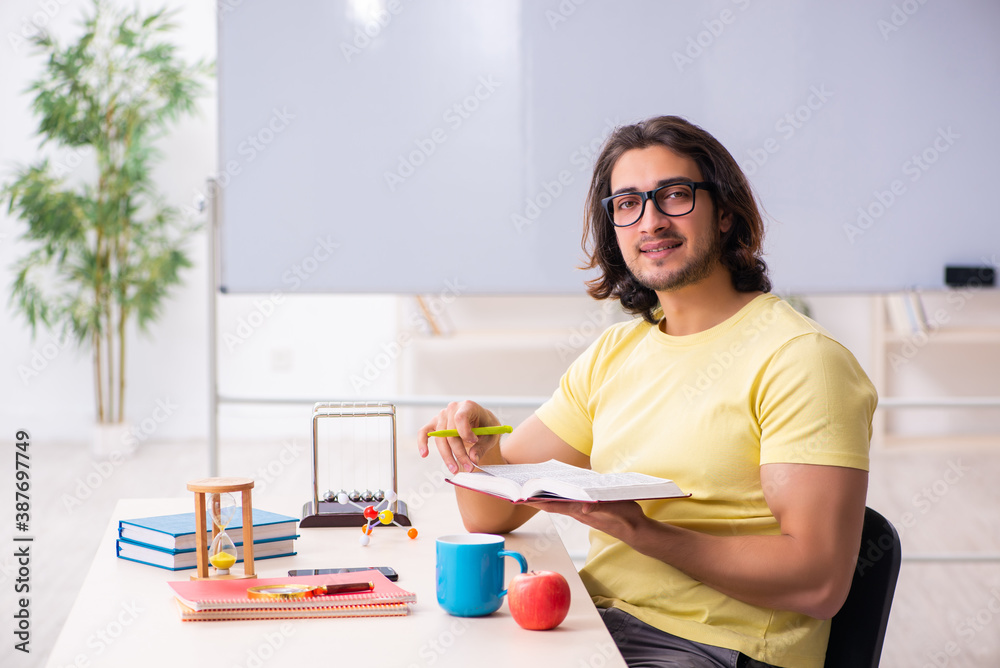 Young male student physicist preparing for exams in the classroo Young male student physicist preparing for exams in the classroo