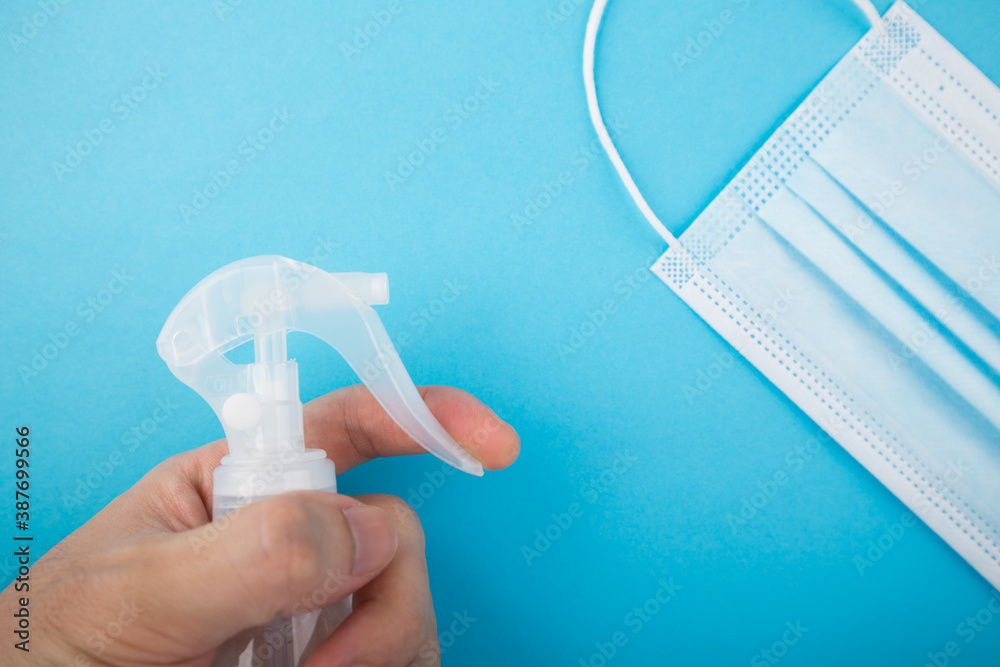 Hand holding the spray bottle against the mask Hand holding the spray bottle against the mask