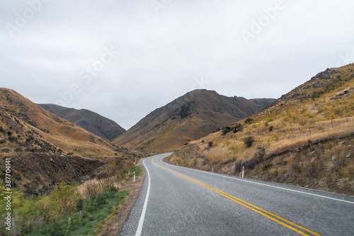 long road in yellow grass valley with sky and white cloud