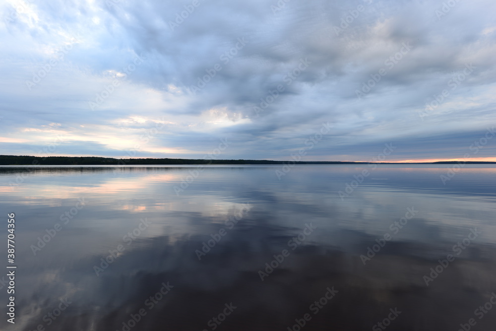 Dusk sky in the reflex on the calm water surface lake