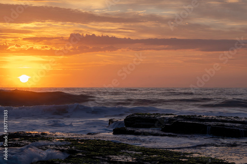 Orange sunrise over Turimetta Beach  on the northern beaches in Sydney Australia. It is 350 metres long and is backed by steep bluffs