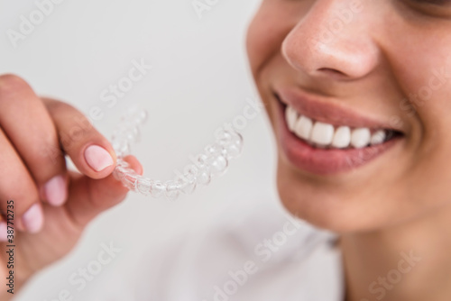 girl with a beautiful smile holding a transparent mouth guard