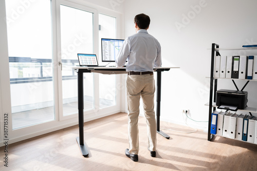 Man Working On Computer At Standing Desk