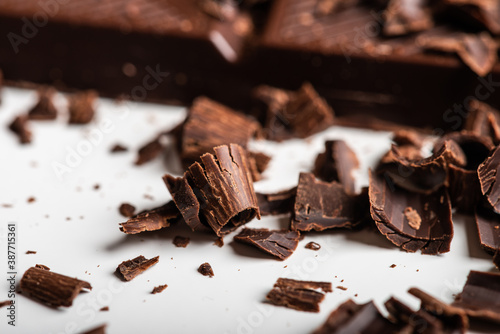 Curls and pieces of tasty chocolate on white table