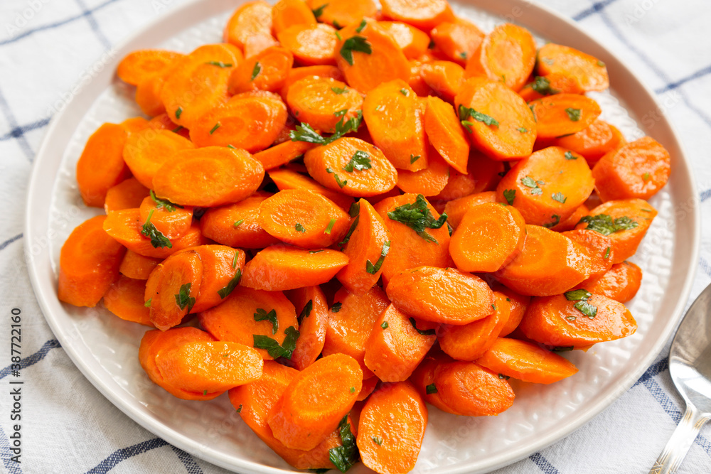 Homemade Sauteed Carrots on a plate, low angle view. Close-up. Homemade Sauteed Carrots on a plate, low angle view. Close-up.