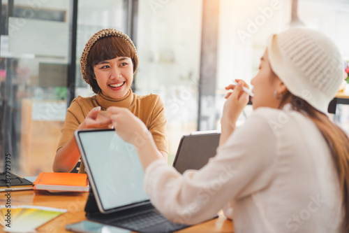 Two young asian women colleagues working together at the modern coworking space.