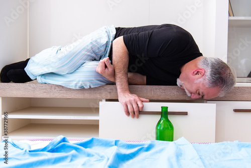 Old man drinking wine in the bedroom