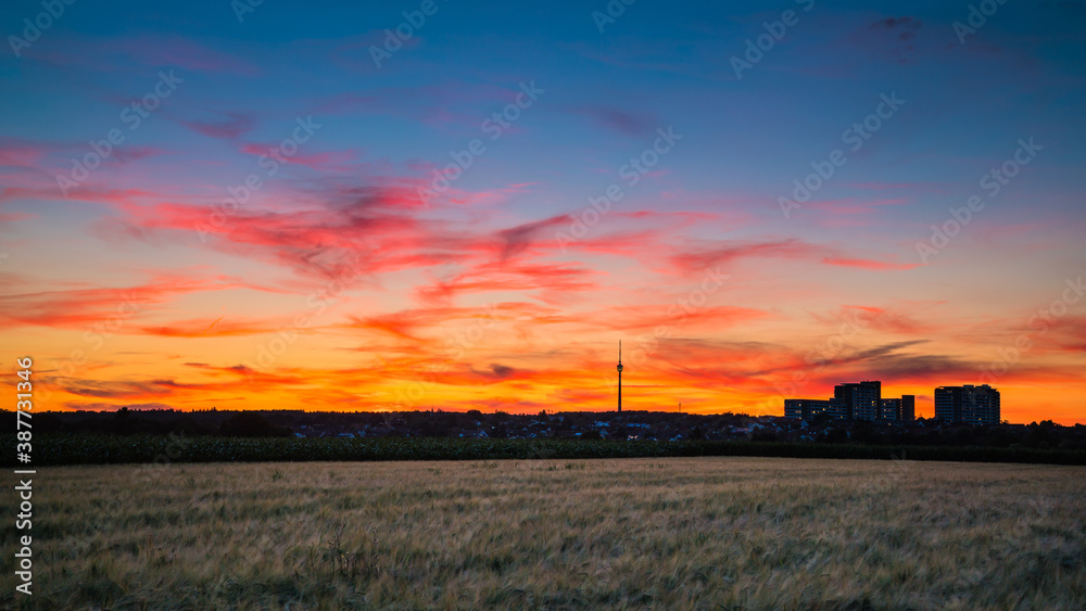 Germany, Stuttgart, Dramatic red glowing sunset sky above fields and tv tower Fernsehturm in summer at blue hour Germany, Stuttgart, Dramatic red glowing sunset sky above fields and tv tower Fernsehturm in summer at blue hour