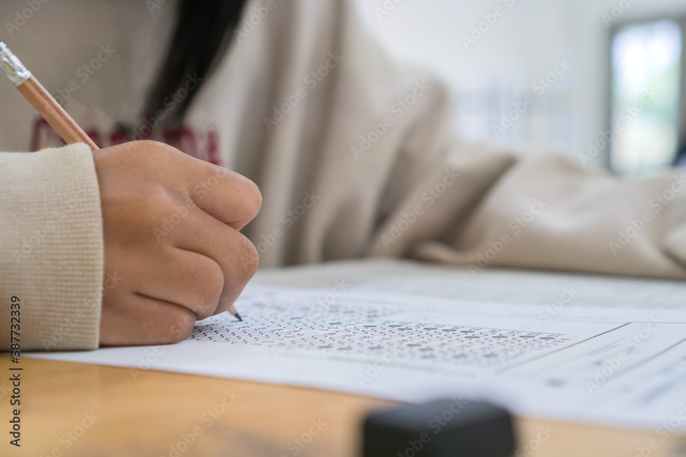 student taking notes lecture in high school or university with holding pencil writing on paperwork sheet and taking final exam in examination classroom student taking notes lecture in high school or university with holding pencil writing on paperwork sheet and taking final exam in examination classroom