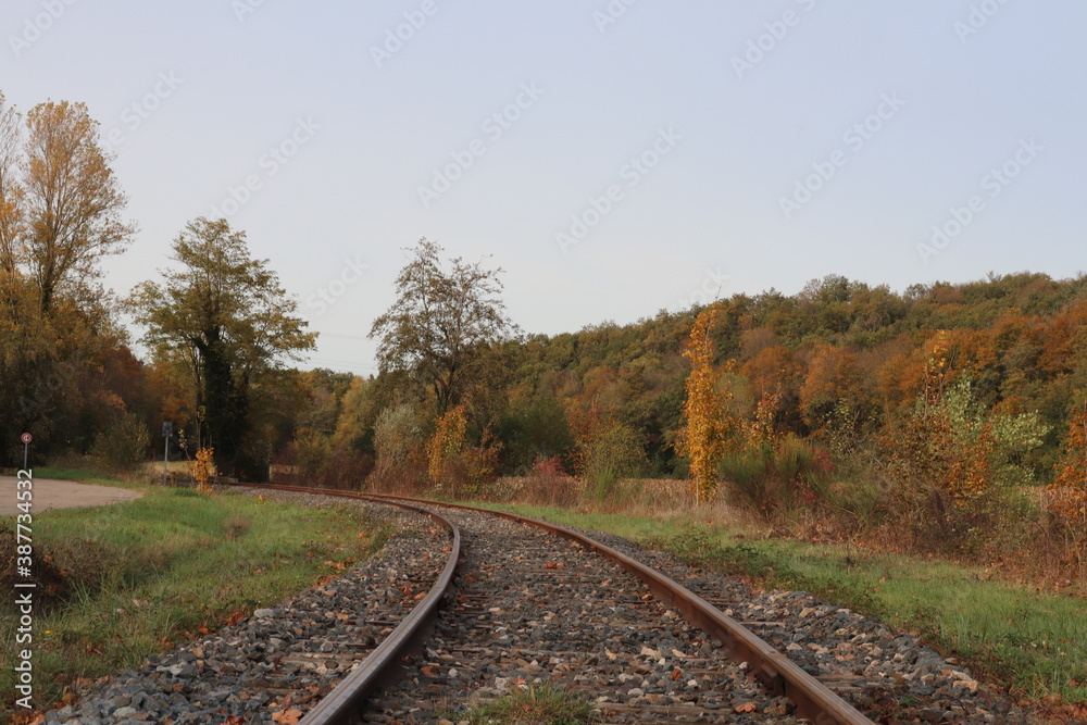 Voie de chemin de fer unique avec traverses en bois de type vignole, au milieu de la campagne en automne, ville de Saint Quentin Fallavier, département de l'Isère, France Voie de chemin de fer unique avec traverses en bois de type vignole, au milieu de la campagne en automne, ville de Saint Quentin Fallavier, département de l'Isère, France