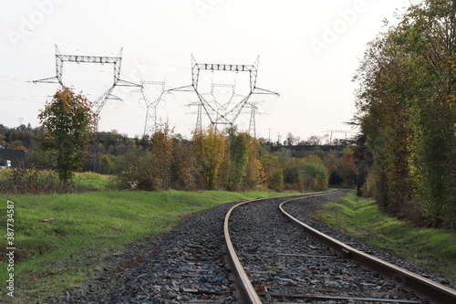 Voie de chemin de fer unique avec traverses en bois de type vignole, au milieu de la campagne en automne,  ville de Saint Quentin Fallavier, département de l'Isère, France photo