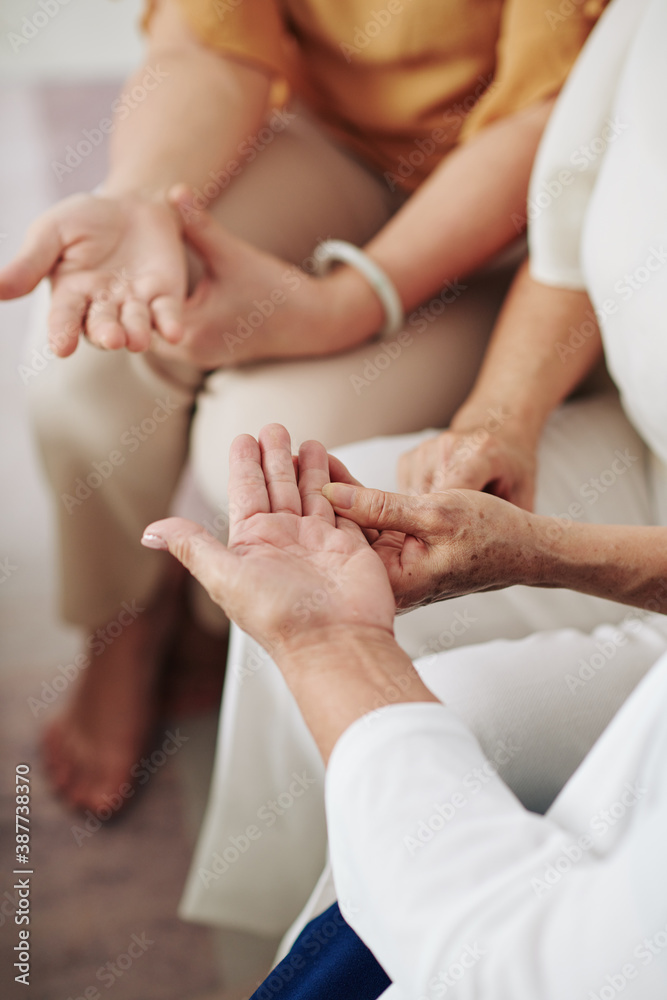 Senior women asking friends to show palms so she could tell fortunes by hand Senior women asking friends to show palms so she could tell fortunes by hand