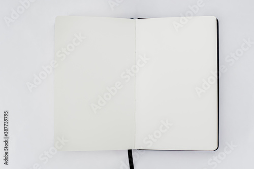 Unfold open notebook with blank white pages on light background. Sketchbook, book photo