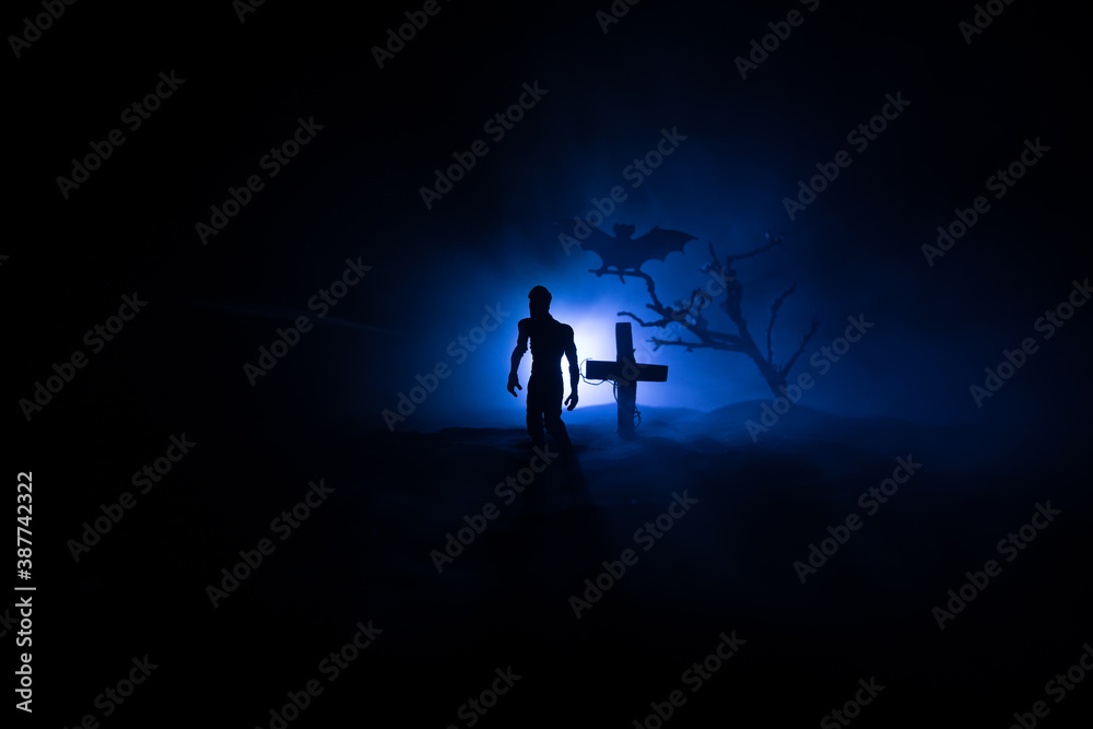 Scary view of zombies at cemetery dead tree, moon, church and spooky cloudy sky with fog, Horror Halloween concept with glowing pumpkin. Selective focus Scary view of zombies at cemetery dead tree, moon, church and spooky cloudy sky with fog, Horror Halloween concept with glowing pumpkin. Selective focus