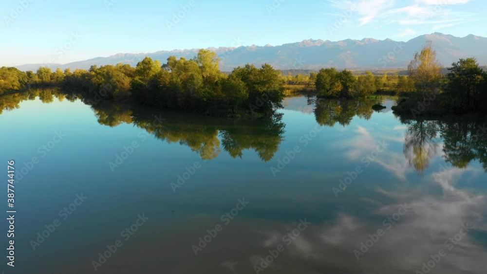 Aerial view. Lake at the edge of the mountains with forest reflected in the clear water. Idyllic autumn landscape. The forest and the sky in the reflection of the water. Quiet autumn fishing landscape Aerial view. Lake at the edge of the mountains with forest reflected in the clear water. Idyllic autumn landscape. The forest and the sky in the reflection of the water. Quiet autumn fishing landscape