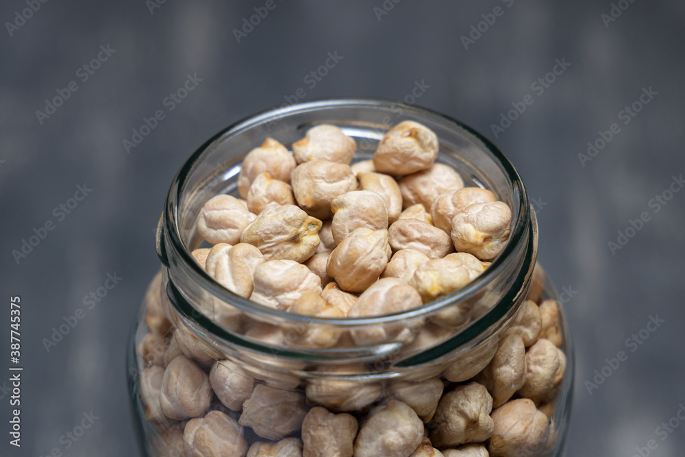 Close up of a glass jar full of chickpeas placed on a tabletop. Eco friendly concept Close up of a glass jar full of chickpeas placed on a tabletop. Eco friendly concept