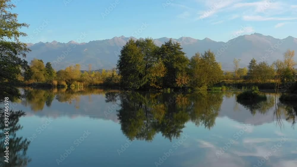 Aerial view. Lake at the edge of the mountains with forest reflected in the clear water. Idyllic autumn landscape. The forest and the sky in the reflection of the water. Quiet autumn fishing landscape Aerial view. Lake at the edge of the mountains with forest reflected in the clear water. Idyllic autumn landscape. The forest and the sky in the reflection of the water. Quiet autumn fishing landscape