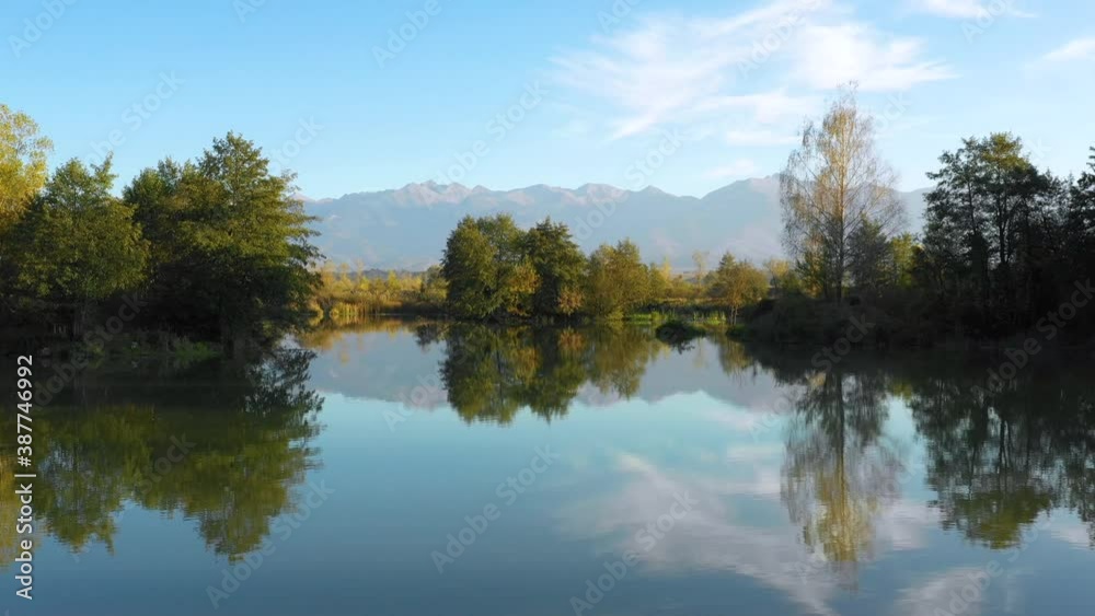 Aerial view. Lake at the edge of the mountains with forest reflected in the clear water. Idyllic autumn landscape. The forest and the sky in the reflection of the water. Quiet autumn fishing landscape Aerial view. Lake at the edge of the mountains with forest reflected in the clear water. Idyllic autumn landscape. The forest and the sky in the reflection of the water. Quiet autumn fishing landscape