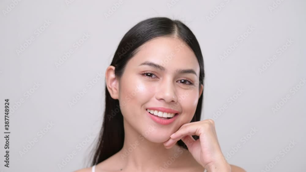Portrait of young beautiful woman with smooth healthy skin, she gently touches her face with her fingers on white grey background , Skincare concept Portrait of young beautiful woman with smooth healthy skin, she gently touches her face with her fingers on white grey background , Skincare concept