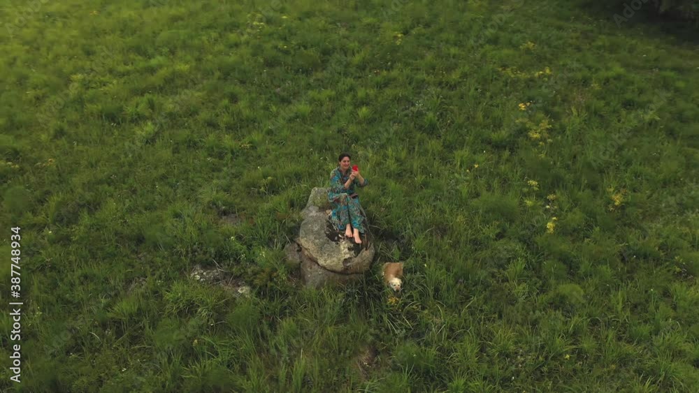 Beautiful woman walks her dog in a beautiful alpine place. Aerial shot. Beautiful woman walks her dog in a beautiful alpine place. Aerial shot.