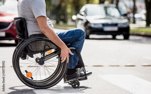 Handicapped man in wheelchair crossing street road