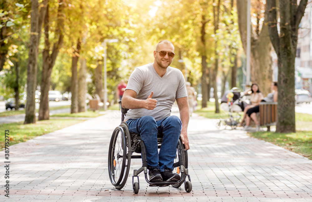 Handicapped man in wheelchair walk at the park alley Handicapped man in wheelchair walk at the park alley