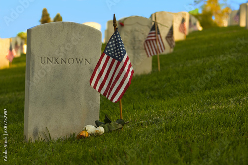 An American flag stands beside the grave of an Unknown service member in the National Cemetery in Los Angeles