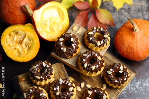Pumpkin muffins with chocolate. Autumn desserts. Autumn composition with poke and cupcakes. Autumn mood.