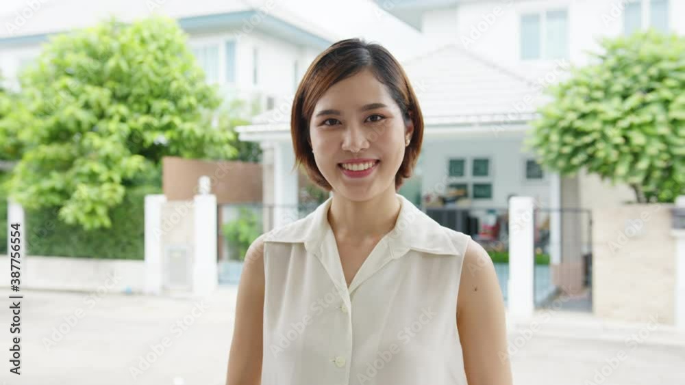 Happy young Asian female feeling happy smiling and looking to camera while relax on street in modern city. Lifestyle woman at outside house concept. Happy young Asian female feeling happy smiling and looking to camera while relax on street in modern city. Lifestyle woman at outside house concept.