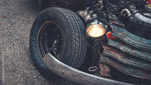 Old ratrod truck detail. Wheel, lights and grill are visible. photo