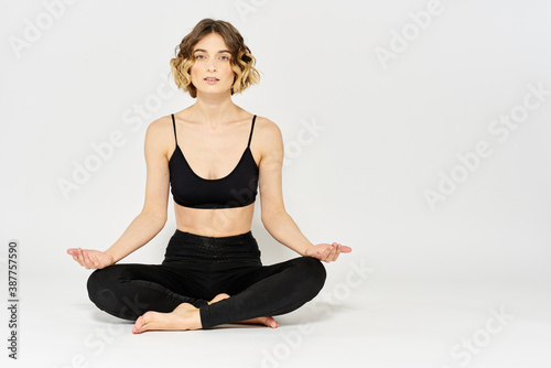 Yoga asana woman crossed legs meditation light background room