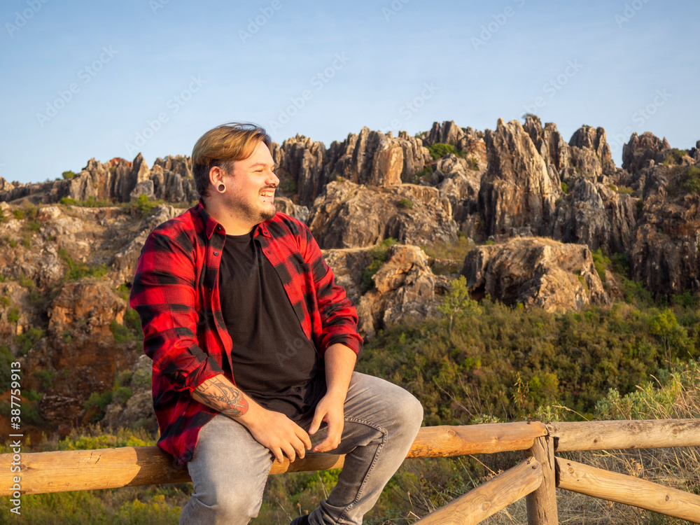 Hombre joven con tatuajes disfrutando de la naturaleza en el cerro del hierro, sevilla, andalucia, españa