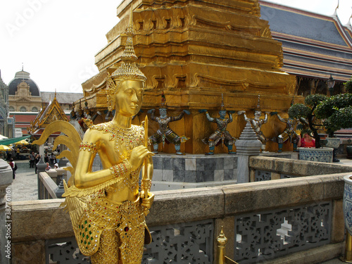 Bangkok, Thailand, January 25, 2013: Golden sculpture next to a stupa at the Royal Palace in Bangkok