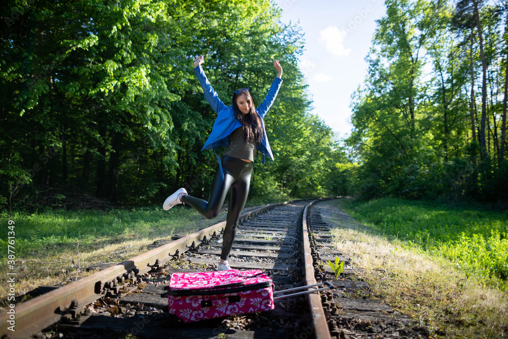 A joyful jump on the railway tracks of a young teenager as she managed