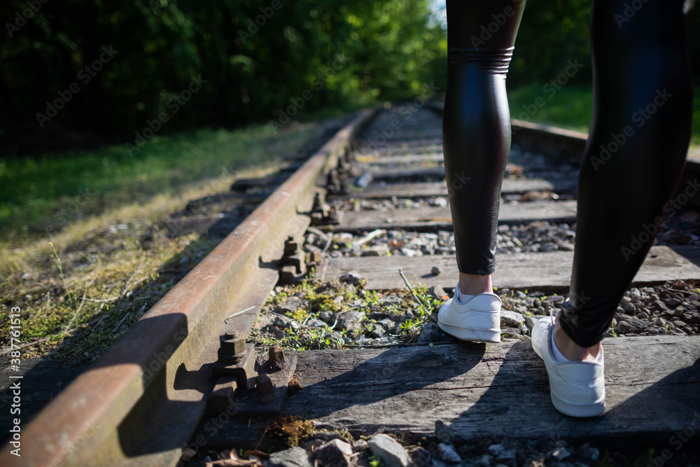 Shapely teenage legs walk on railroad rails wearing black leggings. Stock  Photo | Adobe Stock