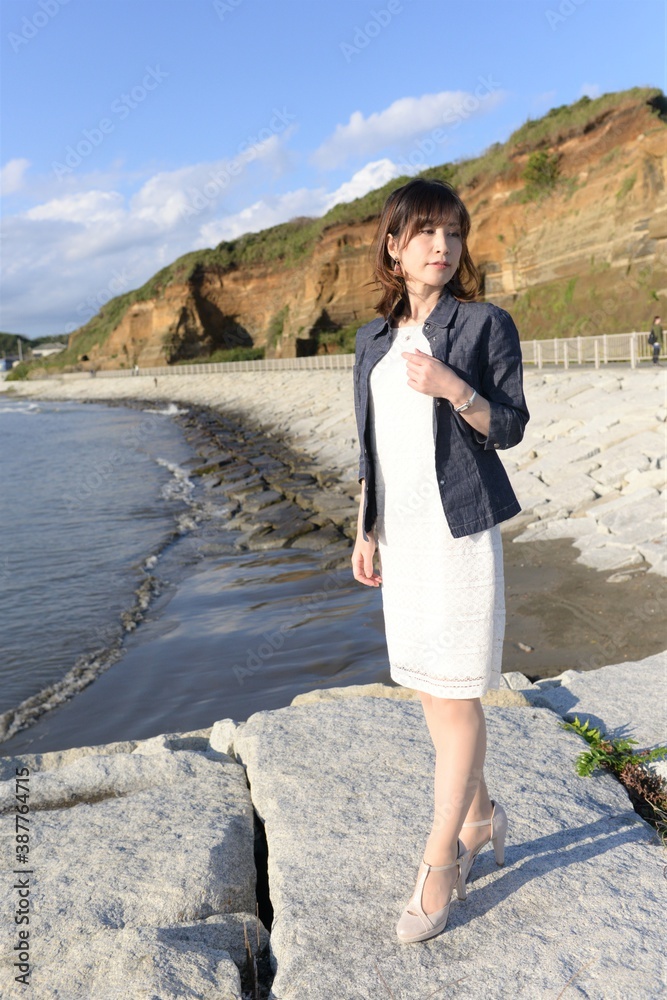 屏風ヶ浦を背景にポーズをとるワンピース姿の若い女性 Stock Foto Adobe Stock