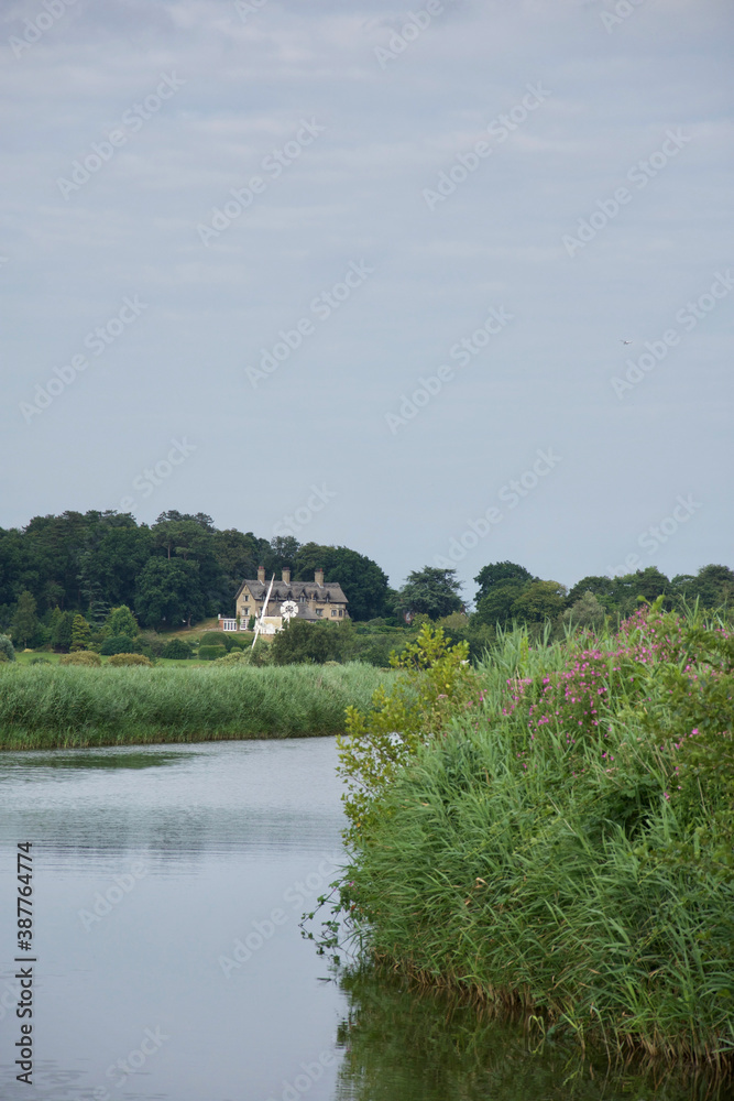 A traditional English thatched house on a bend in a tranquil river A traditional English thatched house on a bend in a tranquil river