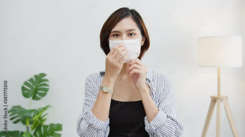 Asia businesswoman wear face mask social distancing in situation for virus prevention looking at camera smiling under surgical mask back to work in office workspace. Lifestyle after corona virus. Asia businesswoman wear face mask social distancing in situation for virus prevention looking at camera smiling under surgical mask back to work in office workspace. Lifestyle after corona virus.