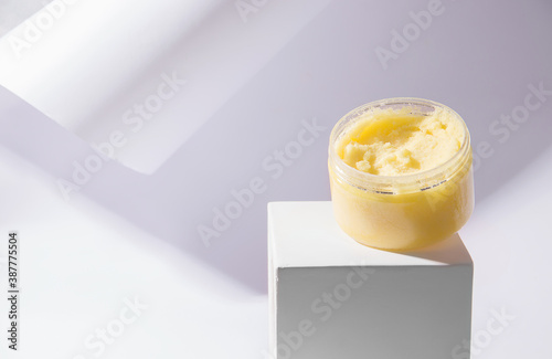 Body scrub yellow on a pedestal. White background. Copy space